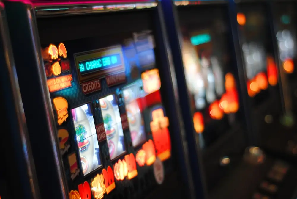 Mesin slot dengan lampu menyala dalam ruangan gelap