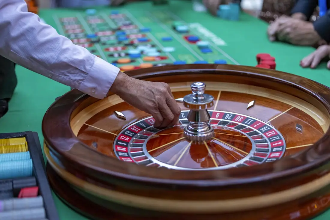 Meja roulette hijau dengan dealer di kasino langsung