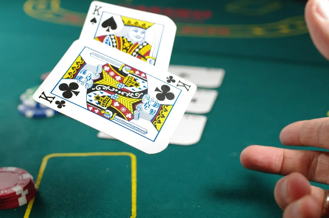 Pemain memegang kartu poker di meja permainan